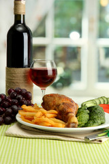 Roast chicken with french fries and cucumbers, glass of wine