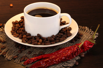 Coffee and pepper on wooden table on brown background