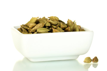 green cardamom in white bowl isolated on white close-up