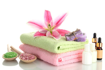Obraz na płótnie Canvas towels with lily, aroma oil, soap and sea salt isolated on