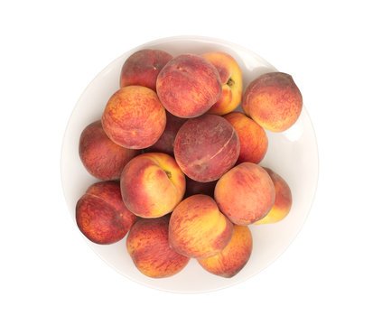 Many fresh Peaches on plate isolated on white