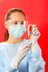 Young woman doctor preparing injection with ampoule and syringe