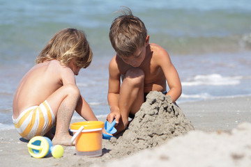 two children playing on sand beach