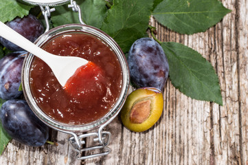 Glass with Plum Jam on wood