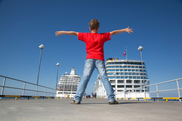 Fototapeta na wymiar little boy spread hands against background two ships
