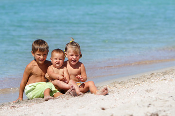 three happy children on sea background