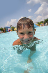 Fototapeta na wymiar outdoor portrait of funny smiling child having fun in aquapark