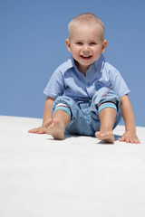 outdoor portrait of young happy child on blue sky background