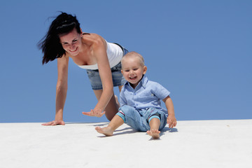 outdoor portrait of young happy mother and child on blue sky bac