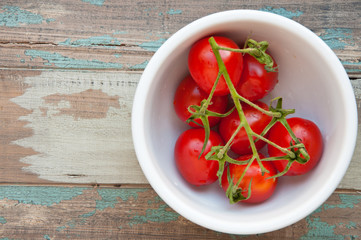 Fresh vine tomatoes in a white bowl.