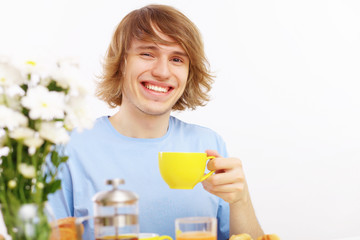 Young happy man drinking tea