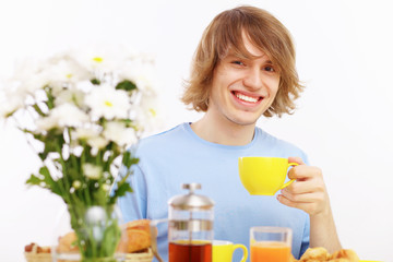 Young happy man drinking tea