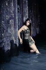 Girl in an evening dress in water
