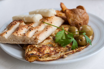 Frühstücksteller mit Eieromelette, Fladenbrot und Oliven