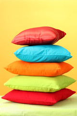 Colorful pillows on yellow background