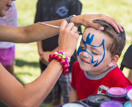 young boy getting his face painted