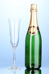 Bottle of champagne and goblet on blue background