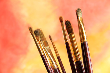brushes on bright abstract gouache painted background