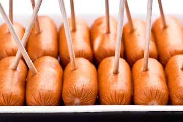 cocktail sausages; punctured tray with chopsticks