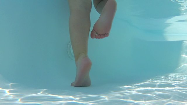 bambina in piscina piedi e gambe