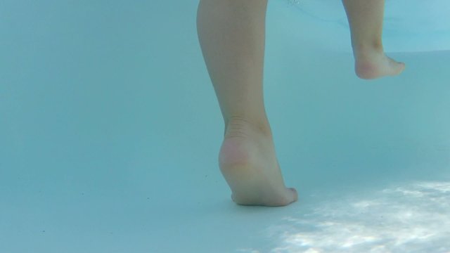 bambina in piscina piedi e gambe