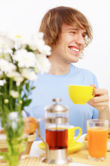 Obraz na płótnie Canvas Young happy man drinking tea