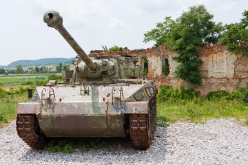 Tank M18 in front of broken house in Croatia