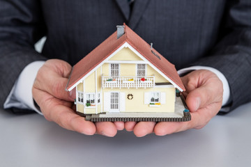 Businessman presenting house model