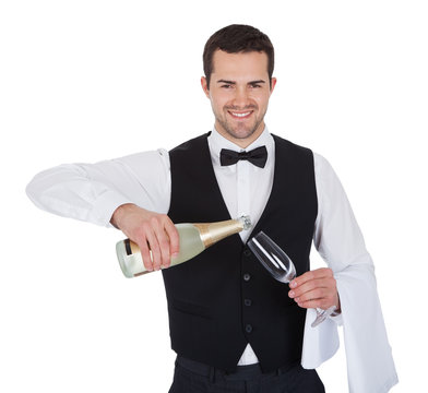 Portrait Of Butler Pouring Champagne Into Glass