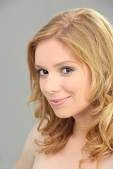 Fototapeta premium Young blond woman with shy smile