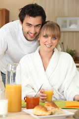 Obraz na płótnie Canvas Couple having breakfast in the kitchen
