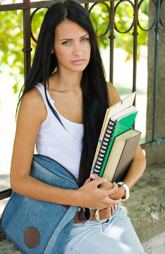 Gorgeous young brunette student girl outdoors.