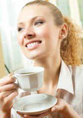 Young woman drinking coffee or tea, at home