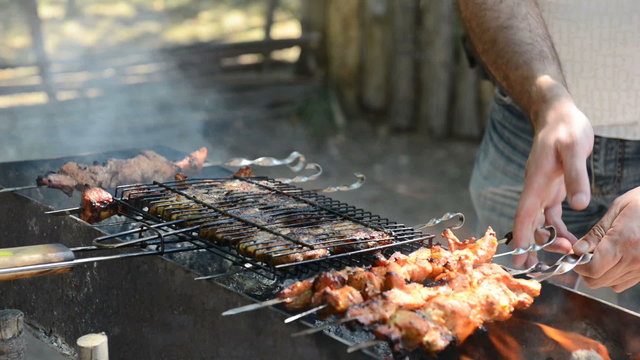 man fries meat on a fire