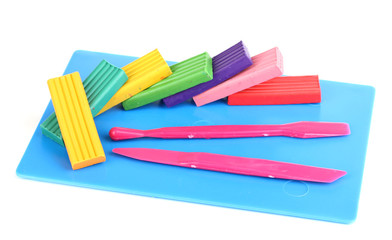 Children bright plasticine on desk with stacks isolated on