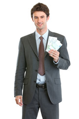 Smiling businessman showing packs of euros