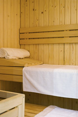Close-up shot of inside of sauna showing bench and towels - stock photo