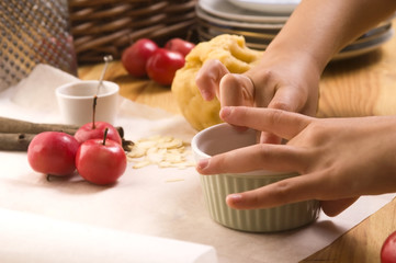 Detail of child hands making apple pie