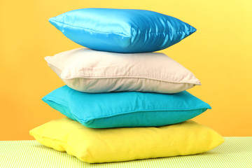 Fototapeta na wymiar Colorful pillows on yellow background