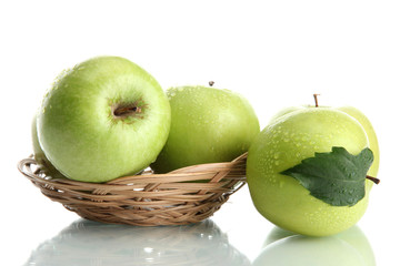 Ripe green apples with leaves in basket isolated on white