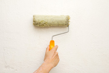 hand with a brush, paint the wall