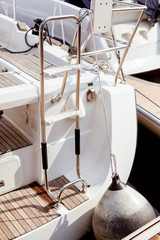 The stern of a boat resting against a fender on a pier