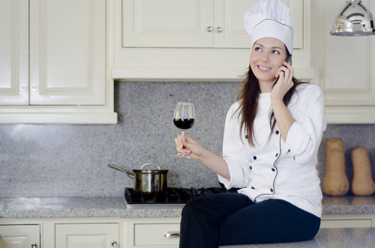 Happy female chef talking on the phone