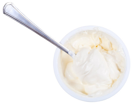 metal spoon in tub of sour cream