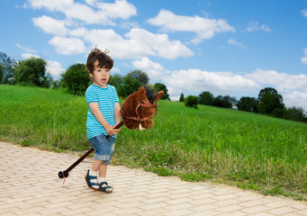 kid playing with horse stick