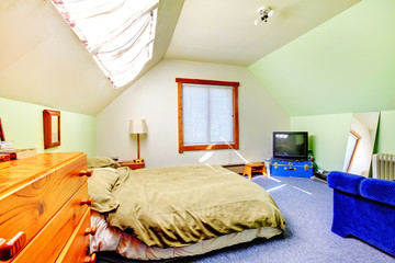 Attic large bright simple bedroom with green walls.