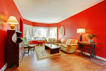 Large red living room with hardwood and antique furniture.