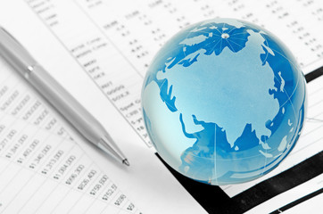 Glass globe and pen on finance