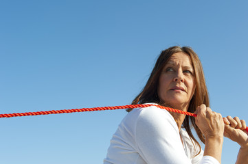 Woman pulling rope sky background