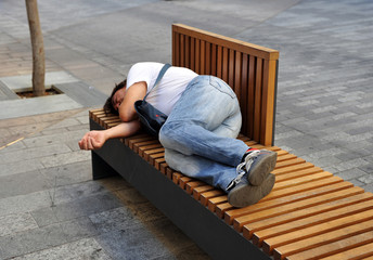 Hombre tumbado en un banco
